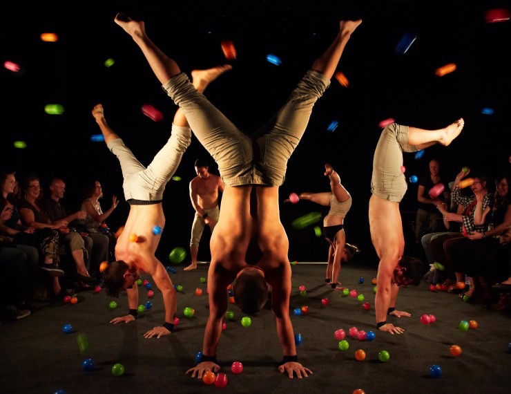 Acrobates faisant des head-stands avec des confetti dans les airs